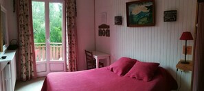 A bedroom with a bed, a desk, a chair, and a window with curtains. - Villa Primerose (Villard-de-Lans)