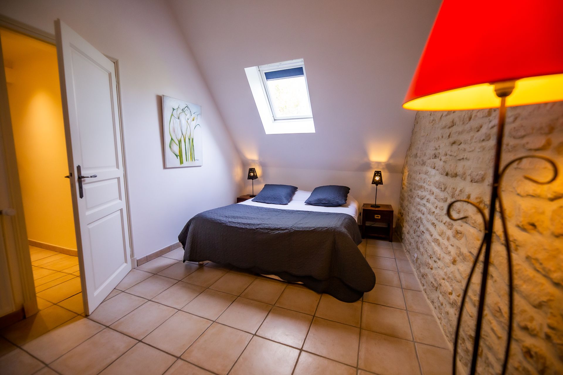 Ein Schlafzimmer mit einem Bett, einem Fenster, einer Wanduhr und einer Lampe.