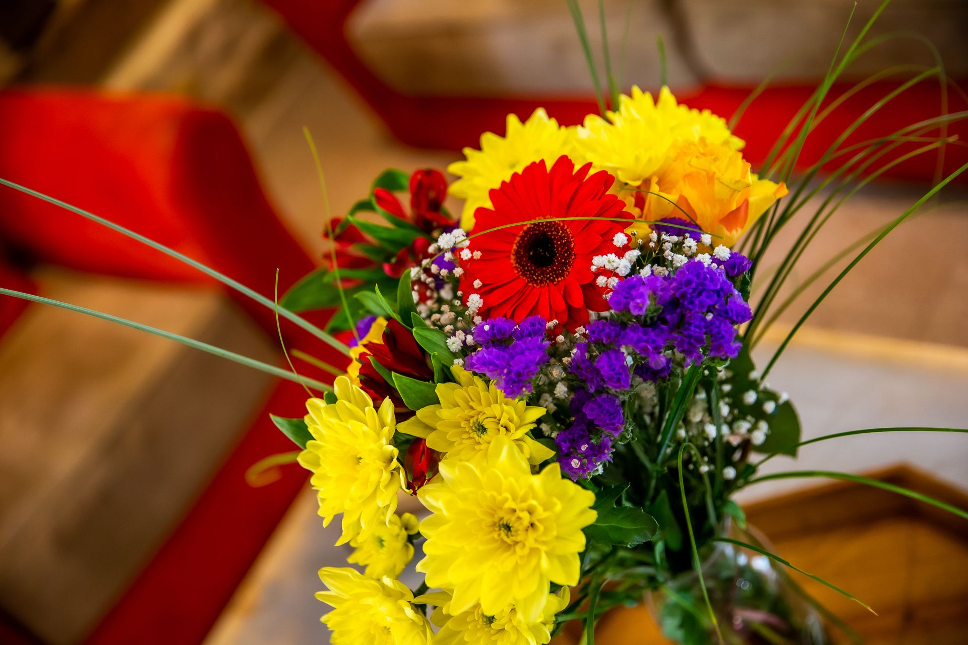 A bouquet of flowers with red, yellow, and purple blooms.