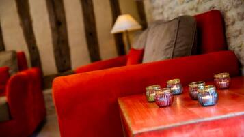 Un canapé rouge, avec une petite table placée devant, sur laquelle sont disposés plusieurs vases décoratifs.