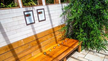 A wooden bench with a white wall behind it, featuring two framed informational signs.
