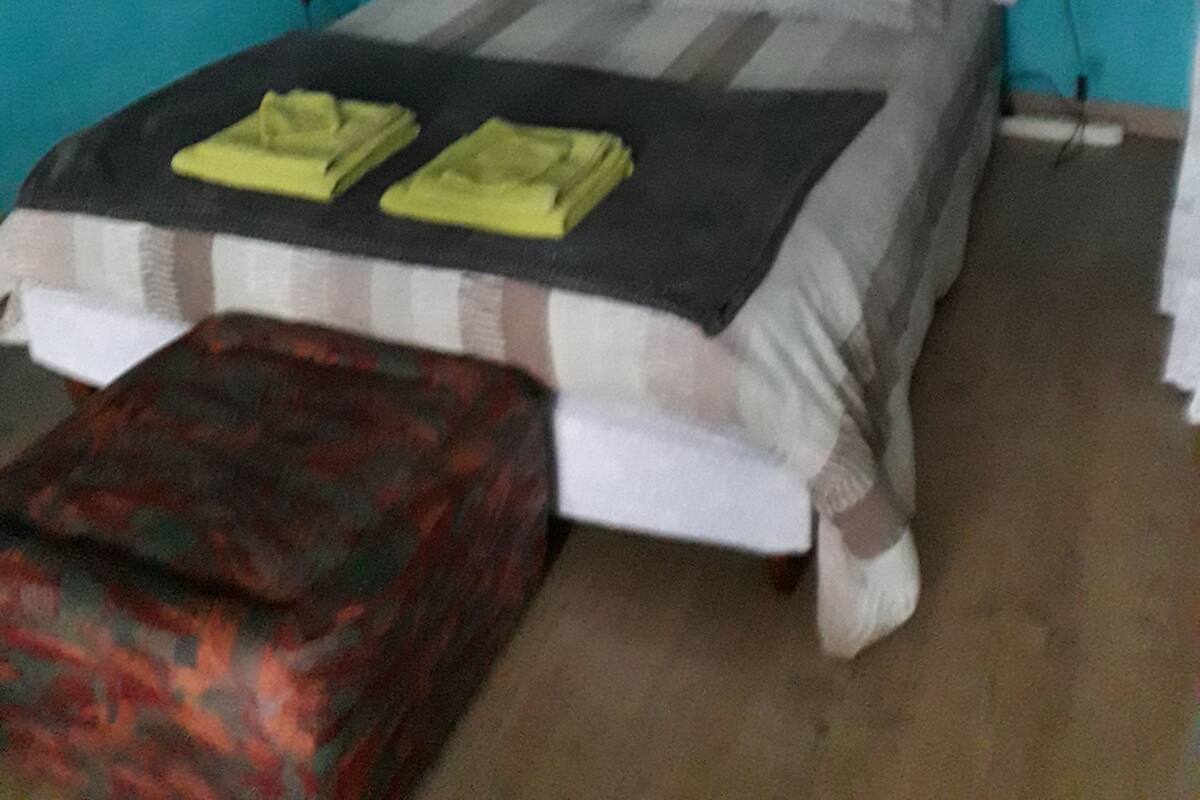 Un dormitorio con cama, mesitas de noche y un accesorio junto a la cama.
