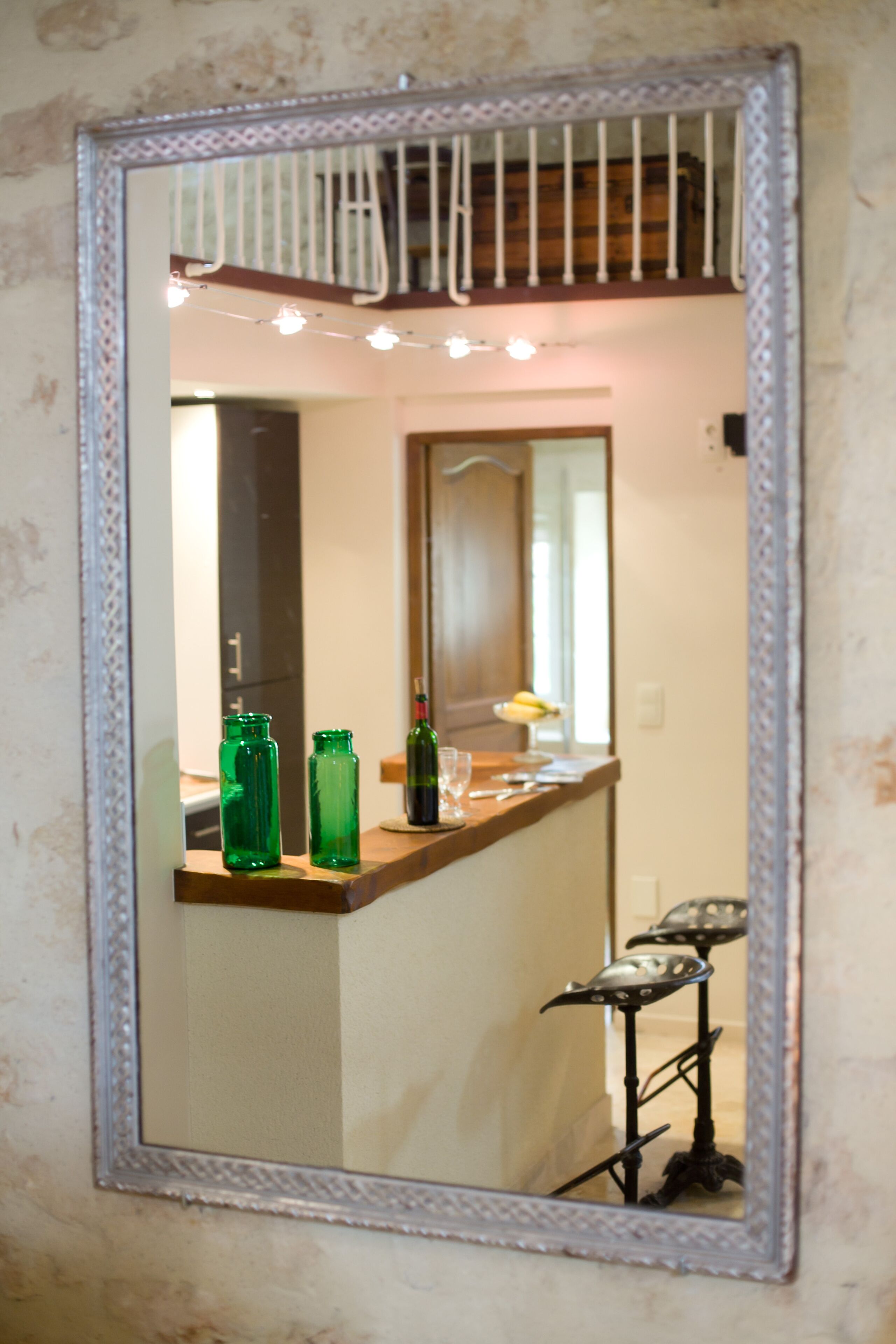 A bathroom with a mirror, a wooden counter, and a small stool.
