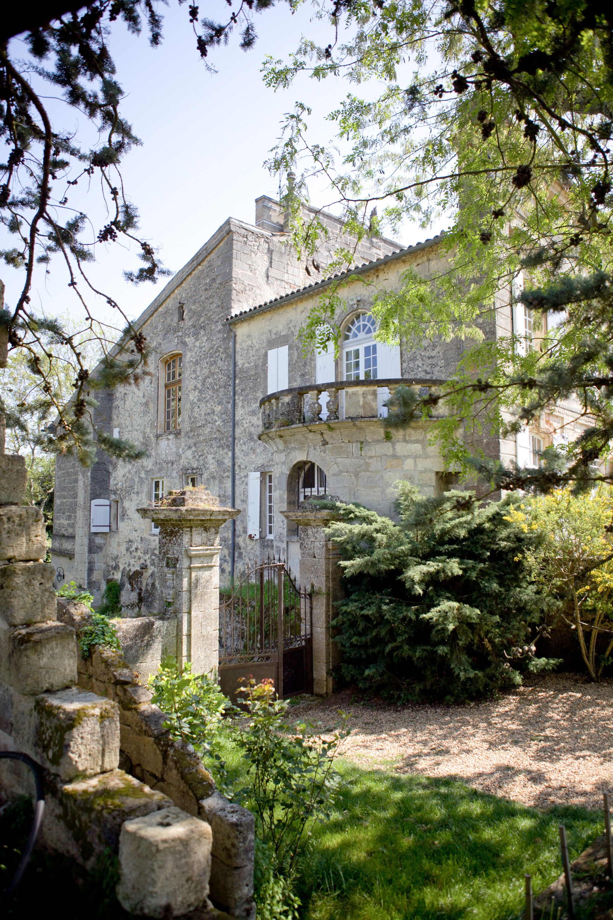 Un edificio histórico de piedra con un patio, una fuente y abundante vegetación.