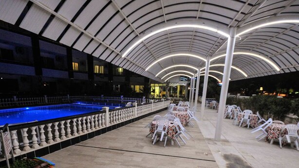 An outdoor pool area with a covered seating area and a pool. - Jasmin Court Apart Otel (Silifke)