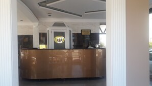 A reception desk with a marble counter and a reception area with a ceiling design. - Jasmin Court Apart Otel (Silifke)
