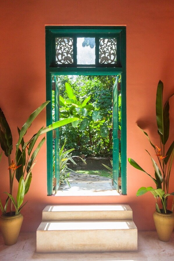 Una puerta con marco verde que da a un jardín.