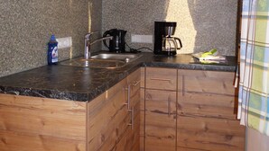A kitchen with wooden cabinets, granite countertops, and a coffee maker. - Liebertingerhof (Reit im Winkl)