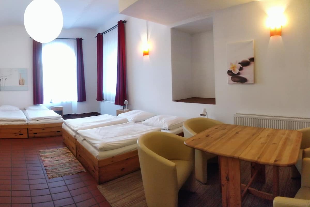 A hotel room with two beds, a wooden table, and a chair.