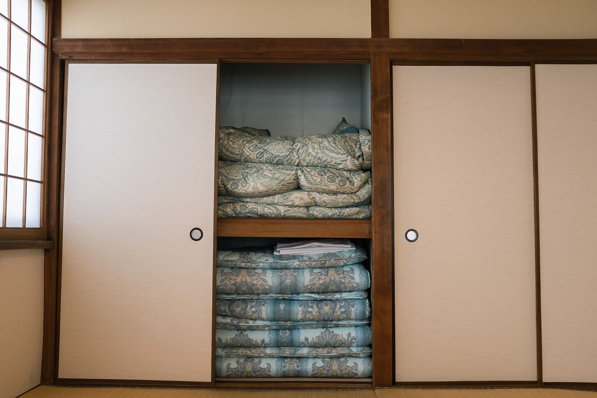 Ein traditioneller japanischer Raum mit Tatami-Boden, einer Shoji-Schiebetür und einem Futon.