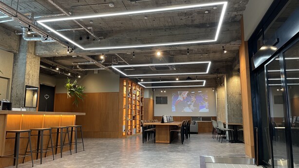 A modern interior with a bar area, seating, and a projection screen.