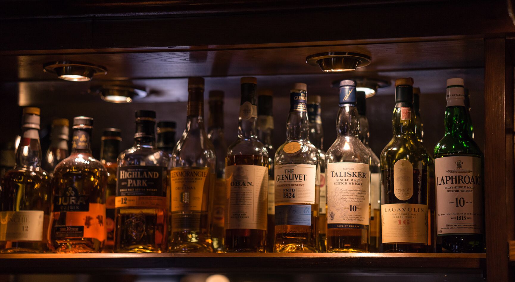 A selection of whisky bottles displayed on a shelf.