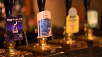 A bar with multiple taps, including one labeled 'Pale Ale MOONSHINE' and another labeled 'BEER'.
