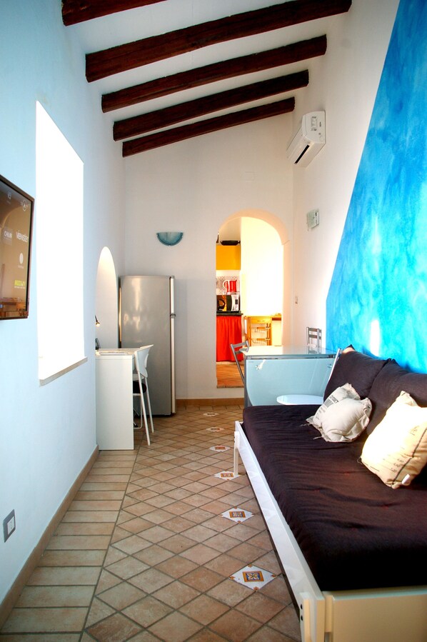 A compact living space with a kitchenette, a bed, and a dining area.
