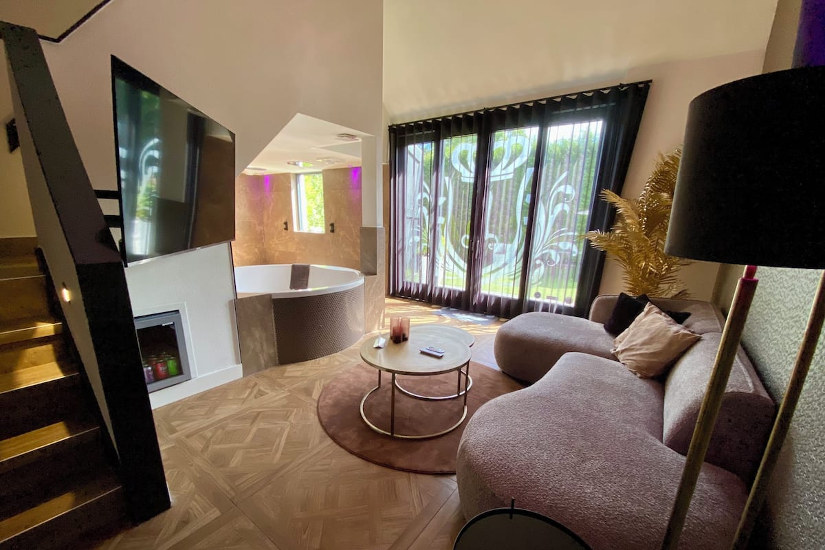 Un salon moderne avec un canapé, une table basse et un téléviseur fixé au mur.