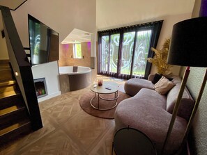 Uma sala de estar moderna com sofá, mesa de centro e TV na parede.