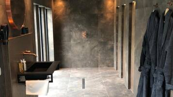 Une salle de bain moderne avec un lavabo noir, un miroir et un porte-serviettes.