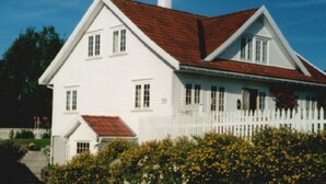 A white house with a red roof and a white picket fence. - Solferie Holiday Home - Svartefjell (Kristiansand)
