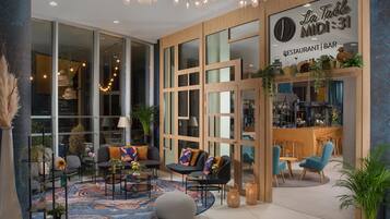 A modern interior with a bar area, seating, and large windows.