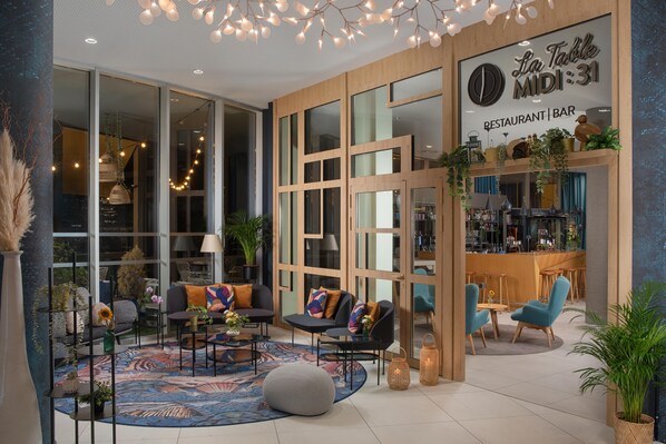 Un interior moderno con una zona de bar, asientos y ventanas amplias.