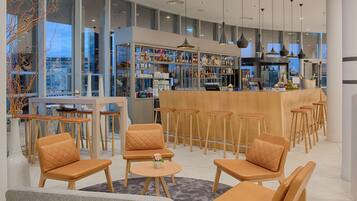 Een moderne bar met houten meubels en een glazen vitrine vol flessen.