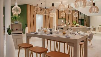 Un comedor moderno con una mesa larga dispuesta para varios invitados, rodeada de sillas y taburetes de madera.