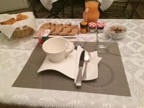 A breakfast table with bread, butter, jam, and a pitcher of juice. - Ida Chambres d'Hôtes Montpellier (Montpellier)