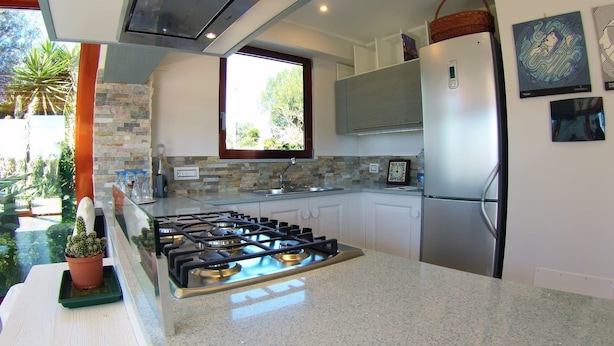 Una cocina moderna con estufa a gas, electrodomésticos de acero inoxidable y vistas al exterior.