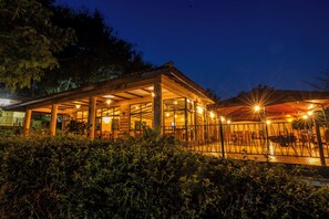 Un bâtiment doté d’un espace extérieur aménagé, couvert et entouré de verdure.