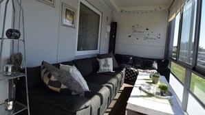 A modern living room with a sofa, a coffee table, and a large window. - Solferie Holiday Home- Gullveien (Kristiansand)