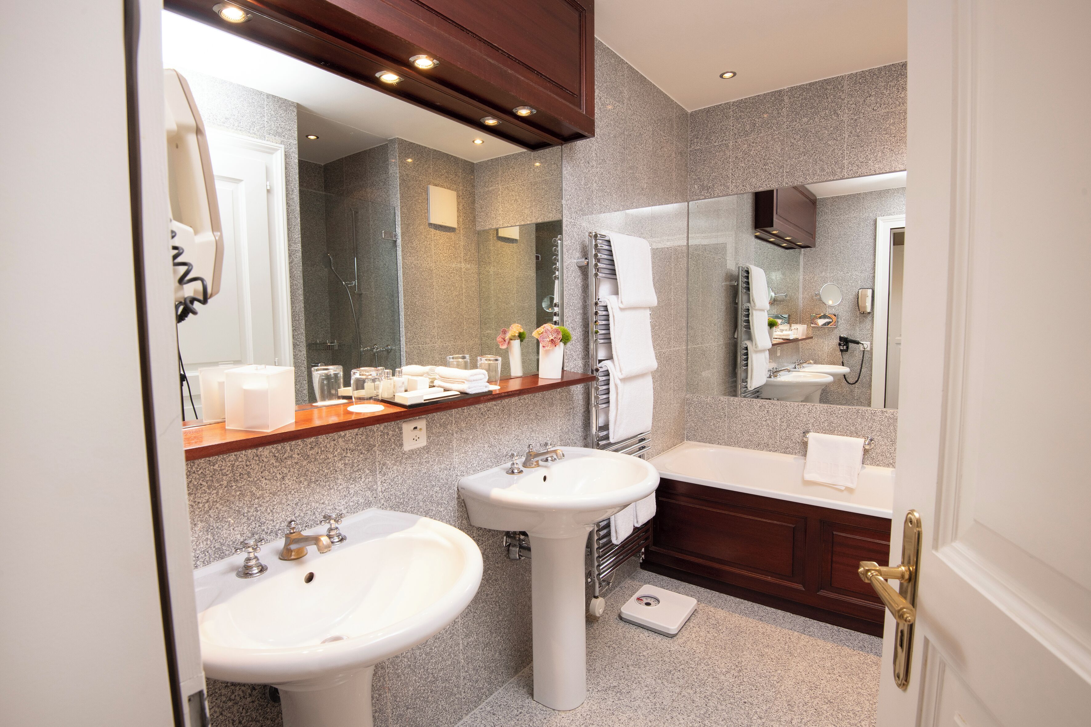 Une salle de bain moderne avec deux lavabos, un meuble-lavabo, une douche et un grand miroir.