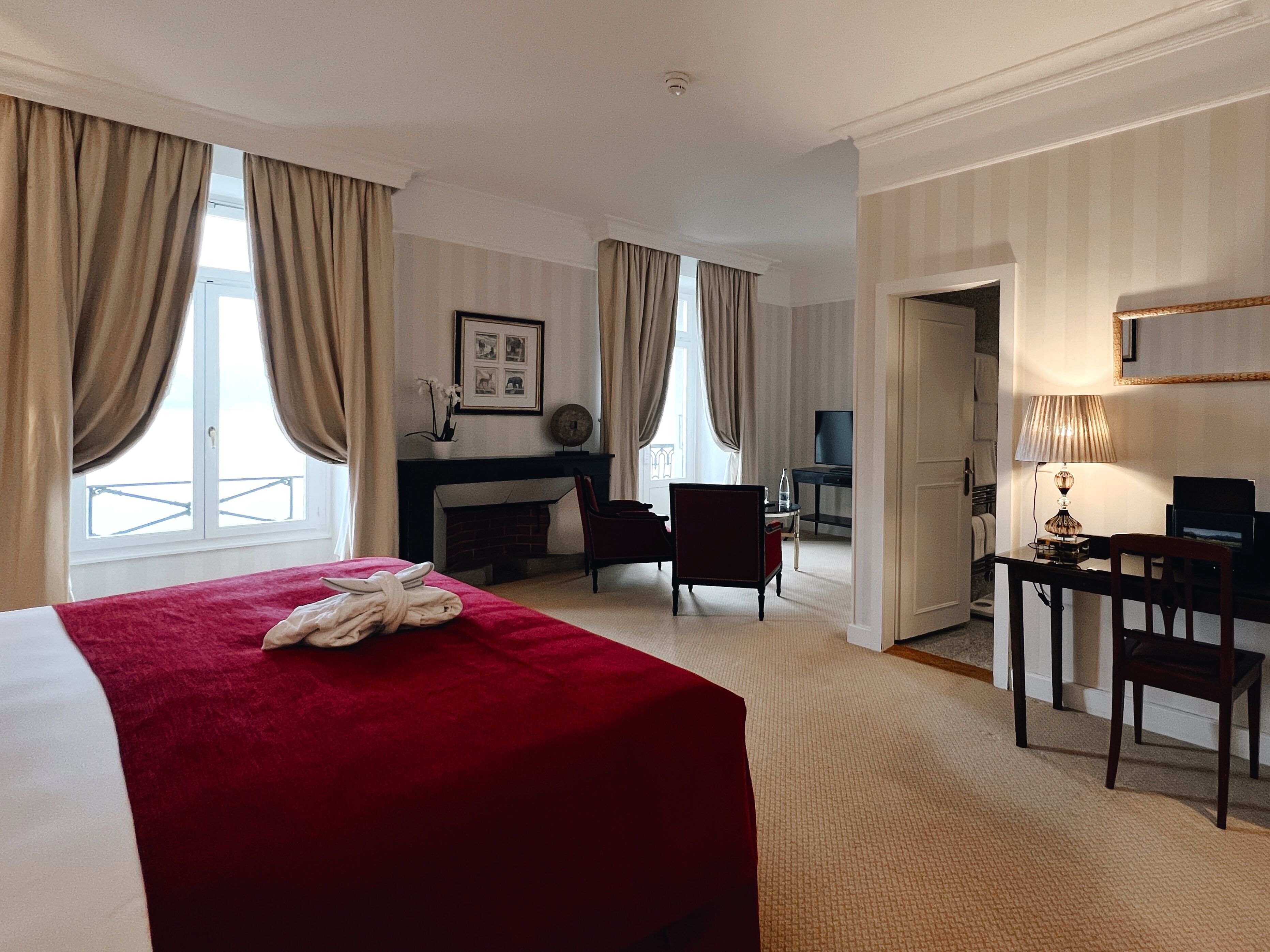 Une chambre d’hôtel avec un grand lit, un bureau avec une chaise, une cheminée et un téléviseur.
