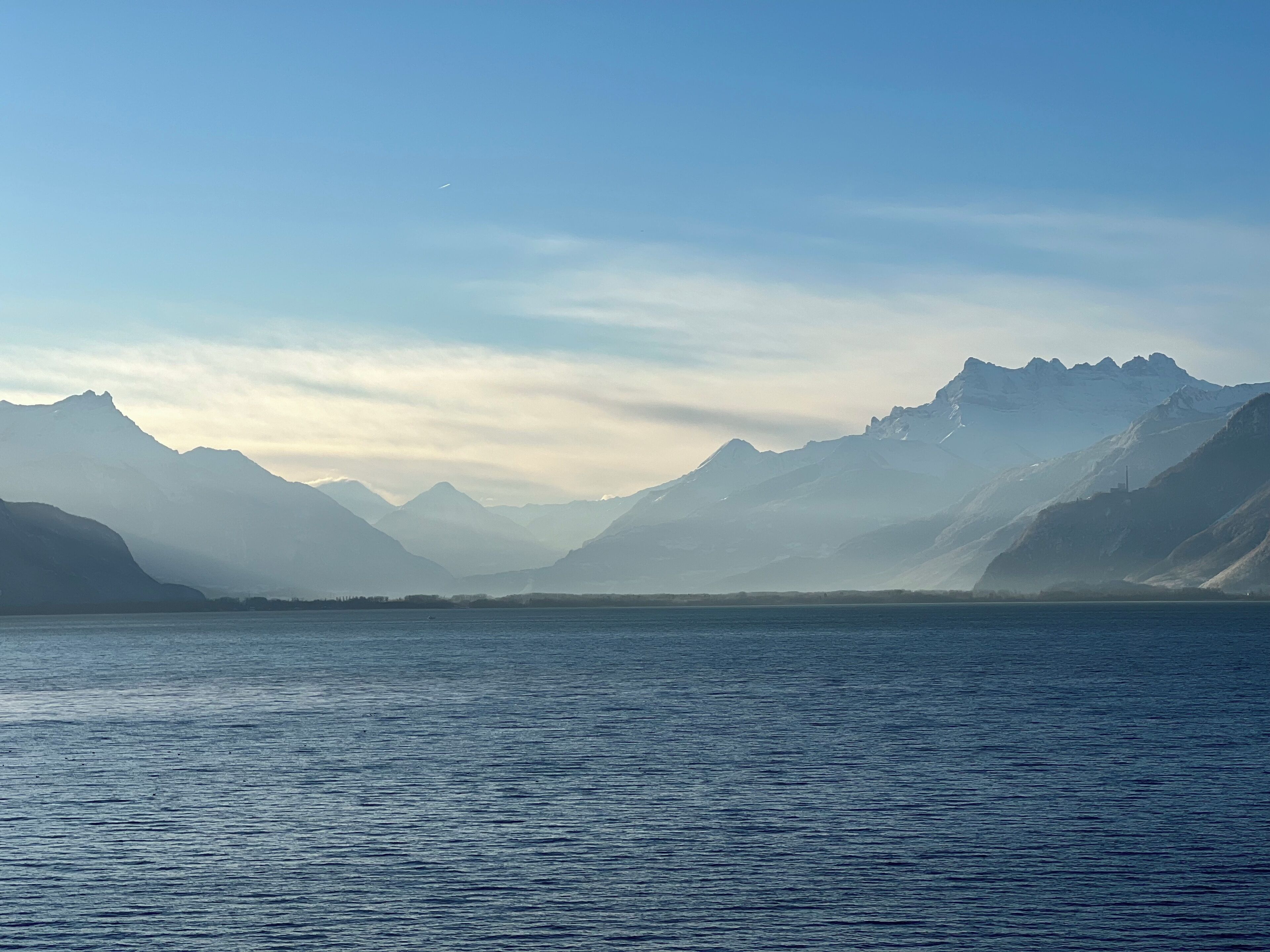 Un lac paisible, avec des montagnes en arrière-plan.