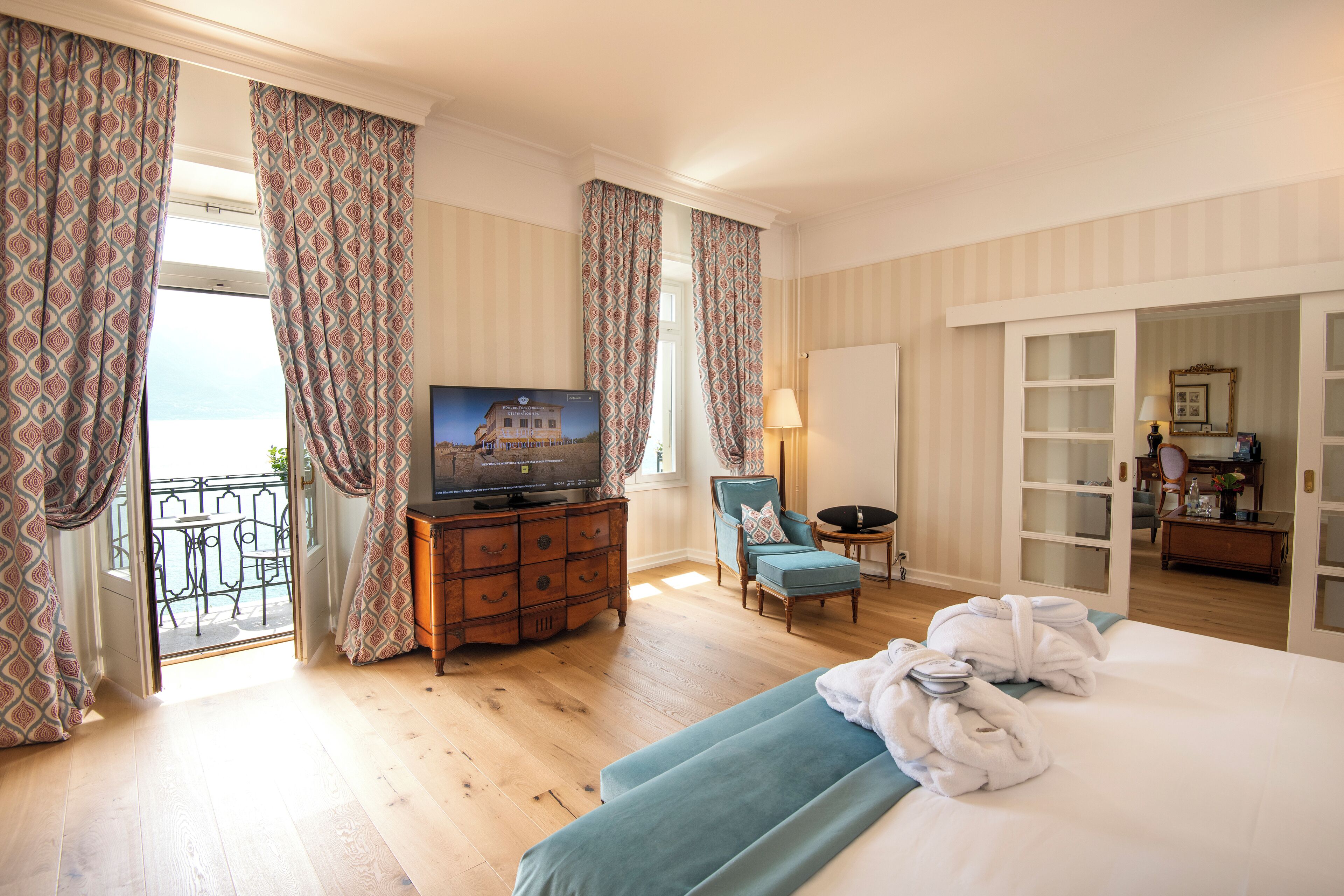 A hotel room with a bed, a TV, a desk, and a chair.