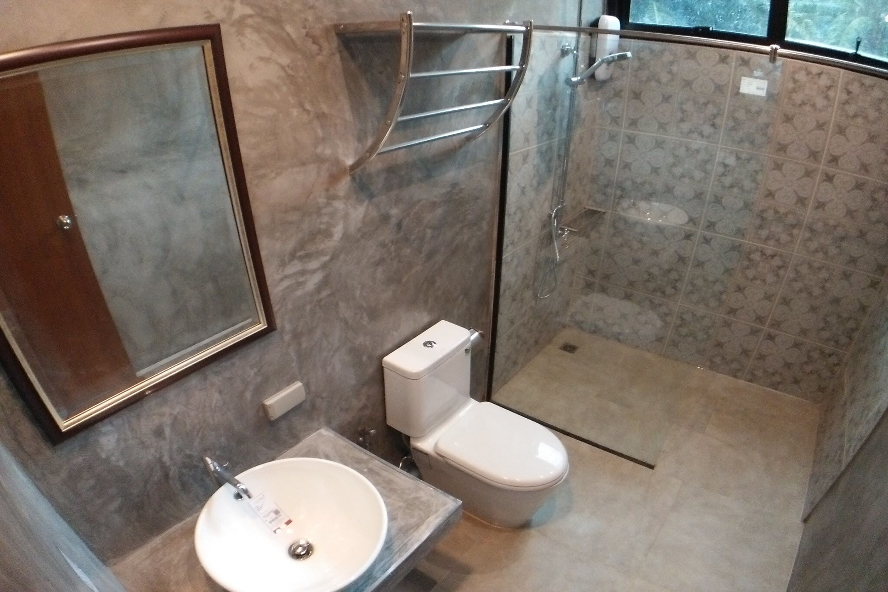 Une salle de bain avec un lavabo en marbre, des toilettes et un espace douche.