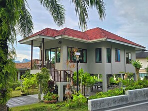A two-story house with a red-tiled roof, large windows, and a balcony. - Krabi Green Hill Pool Villas (Krabi)