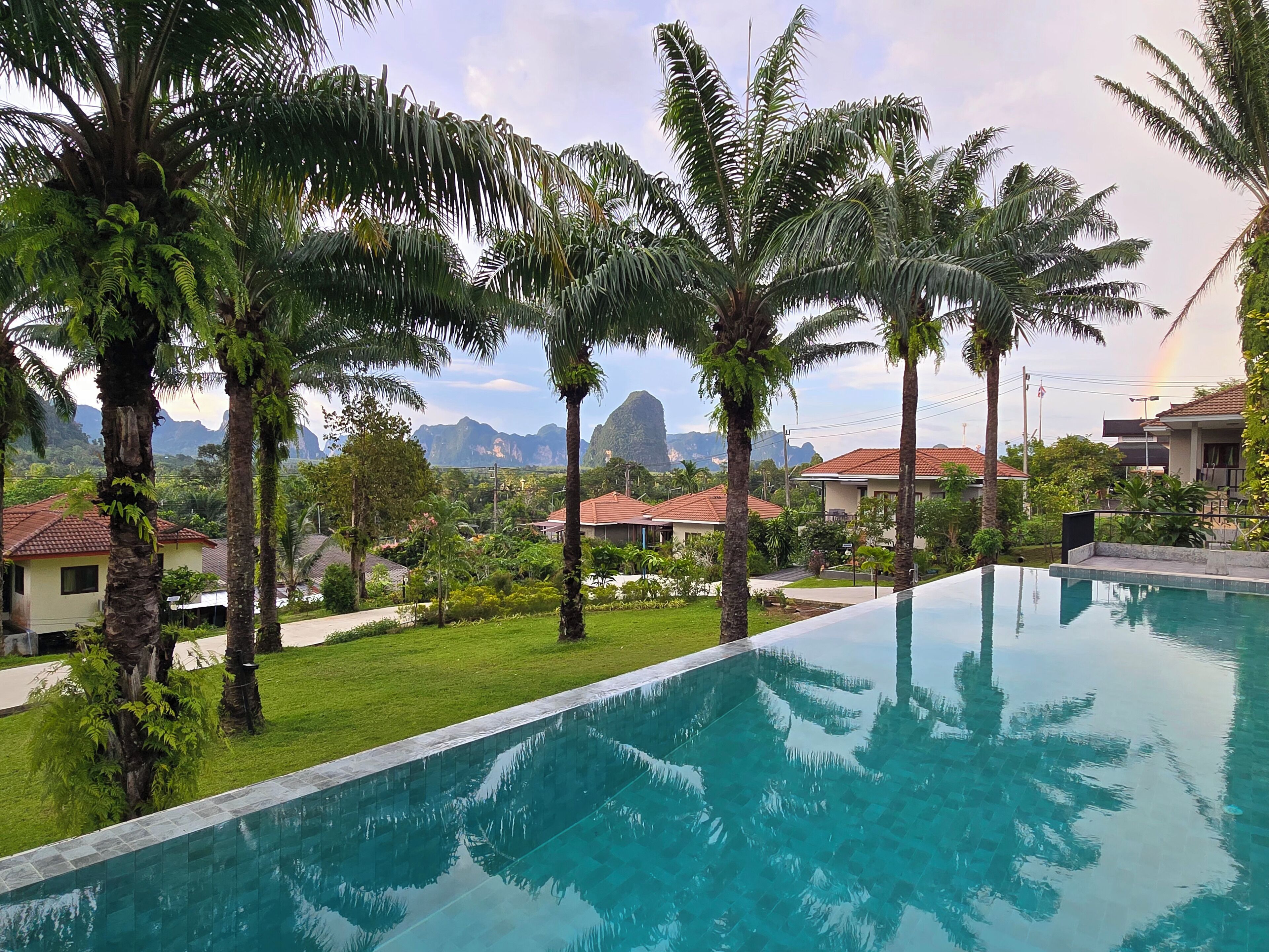 Piscina con vistas a casas y palmeras.