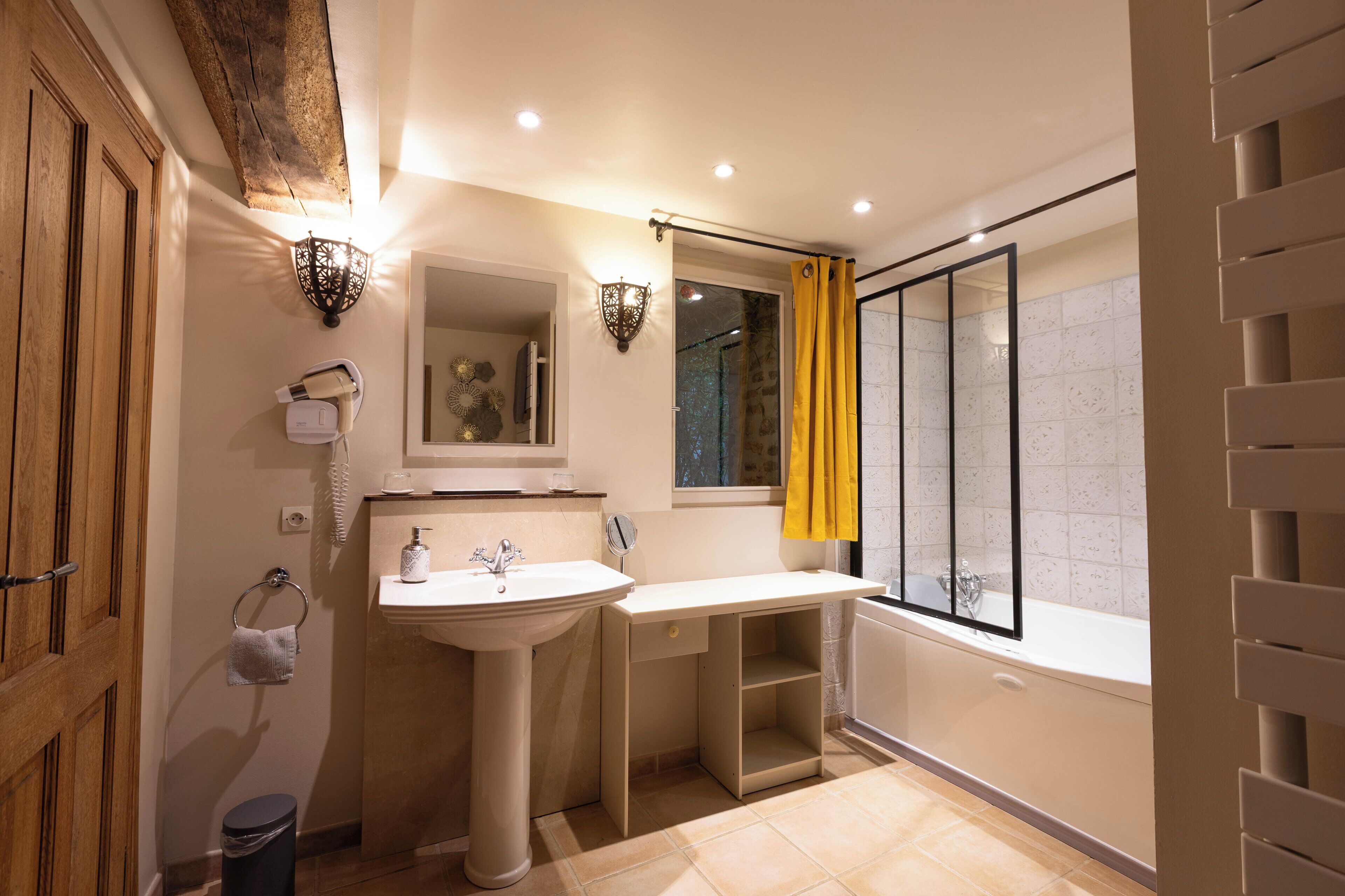 A modern bathroom with a sink, mirror, and bathtub.