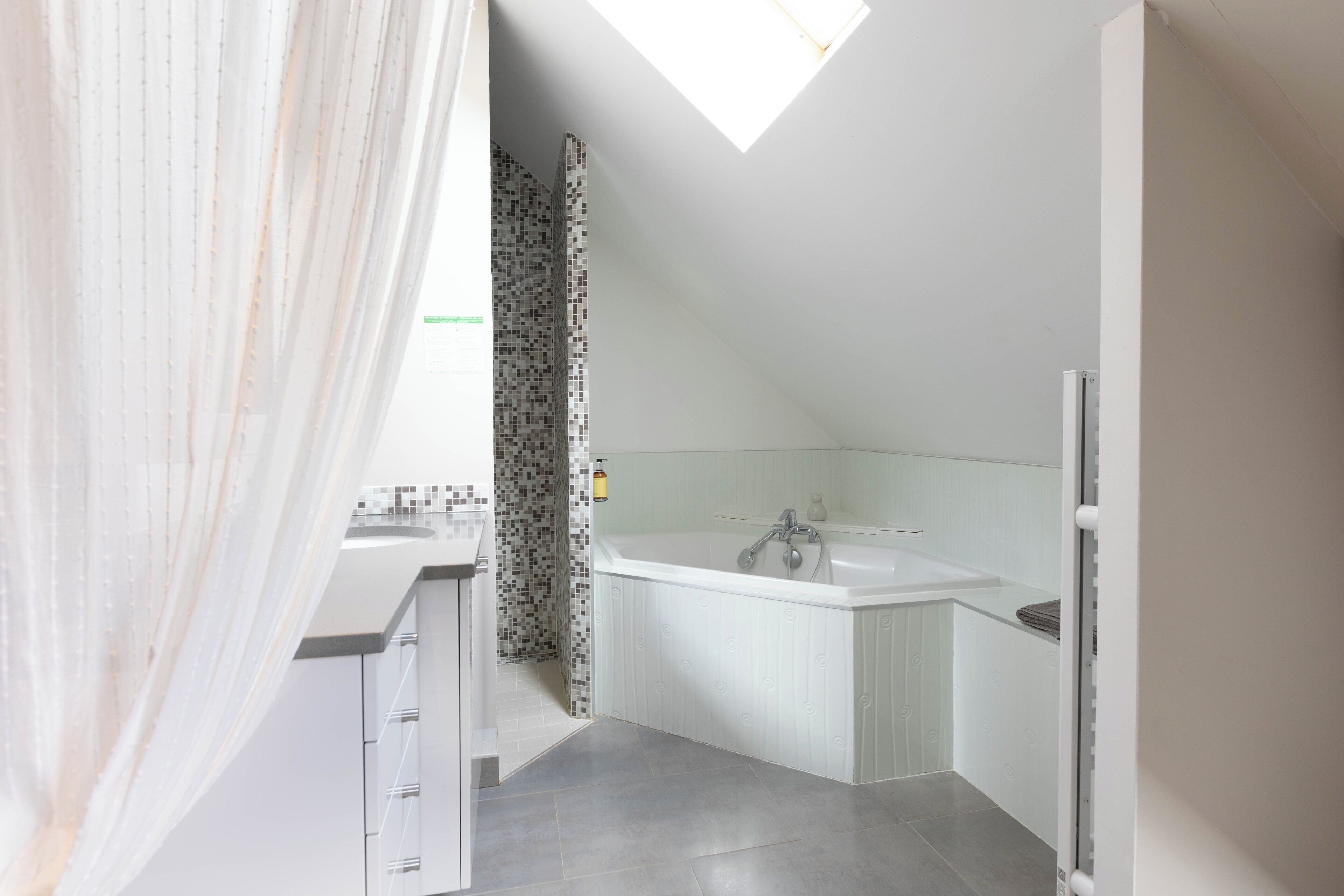 A modern bathroom with a shower, a sink, and a bathtub.