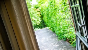 A pathway leading through a lush green area, with a metal gate on the right. - Chambres d'Hôtes La Ferme de L'Oudon & Spa (Saint-Pierre-en-Auge)