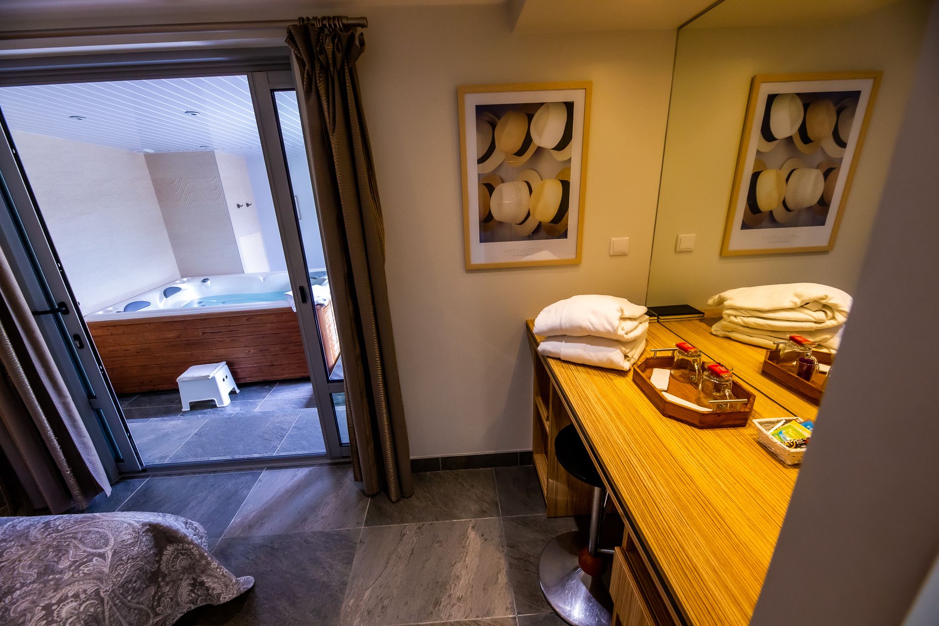 A hotel room with a bed, a bathroom with a mirror, towels, and toiletries on the counter.