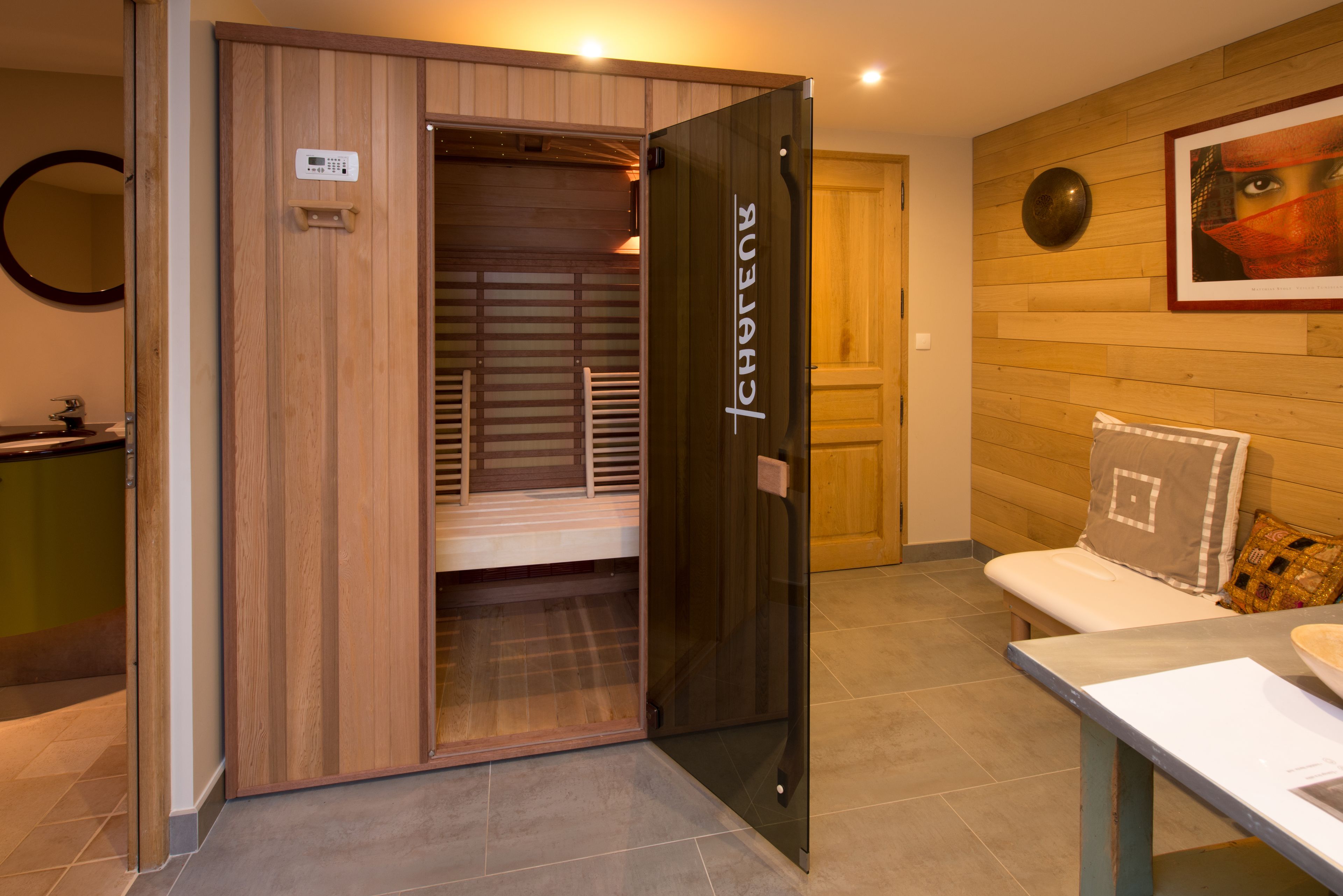 A modern bathroom with a wooden vanity, a glass shower enclosure, and a wooden wall panel.