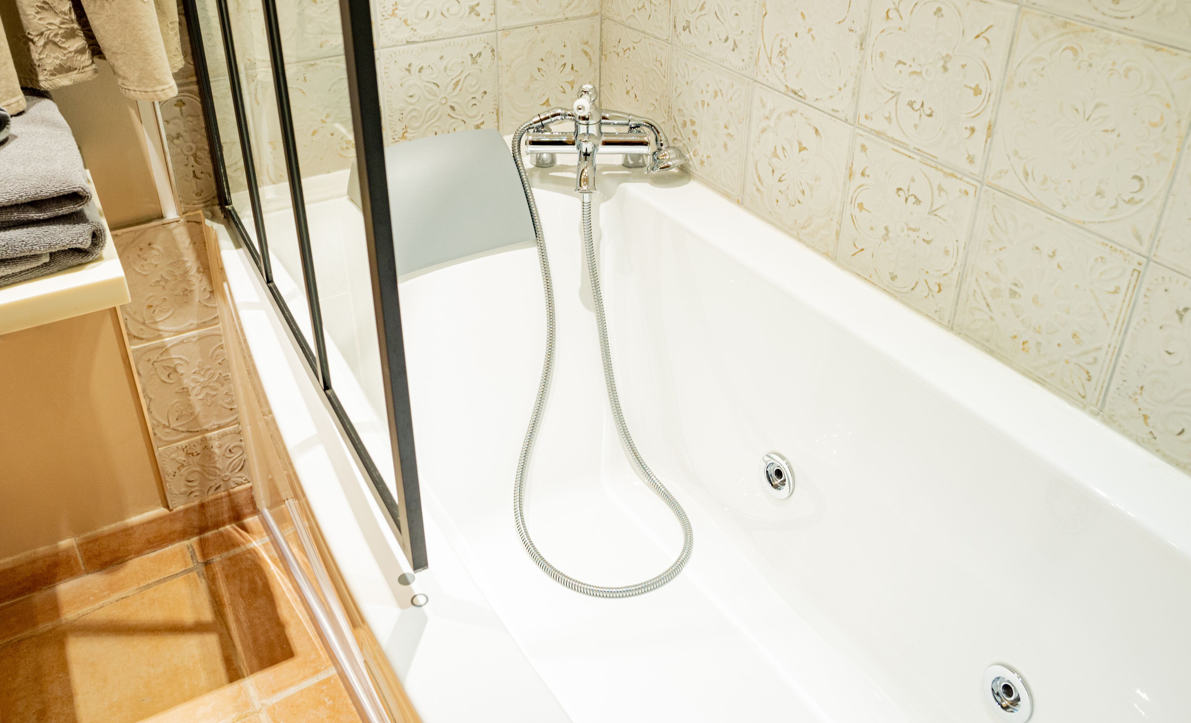 A bathroom with a bathtub, a shower, and a glass door.