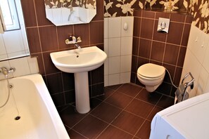 A bathroom with a white sink, a toilet, and a bathtub.