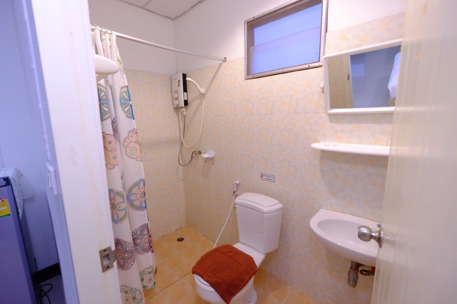 Une petite salle de bain avec une douche, des toilettes et un lavabo.