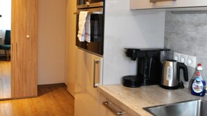 Una cocina moderna con electrodomésticos de acero inoxidable, piso de madera y horno empotrado.