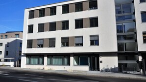 Un edificio moderno de varios pisos con ventanas amplias y fachada plana.