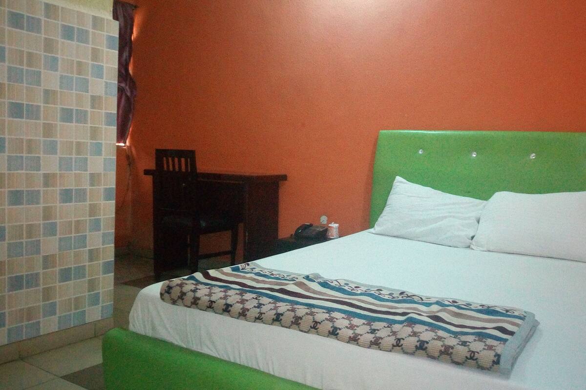 A room with a bed, a chair, and a small table.