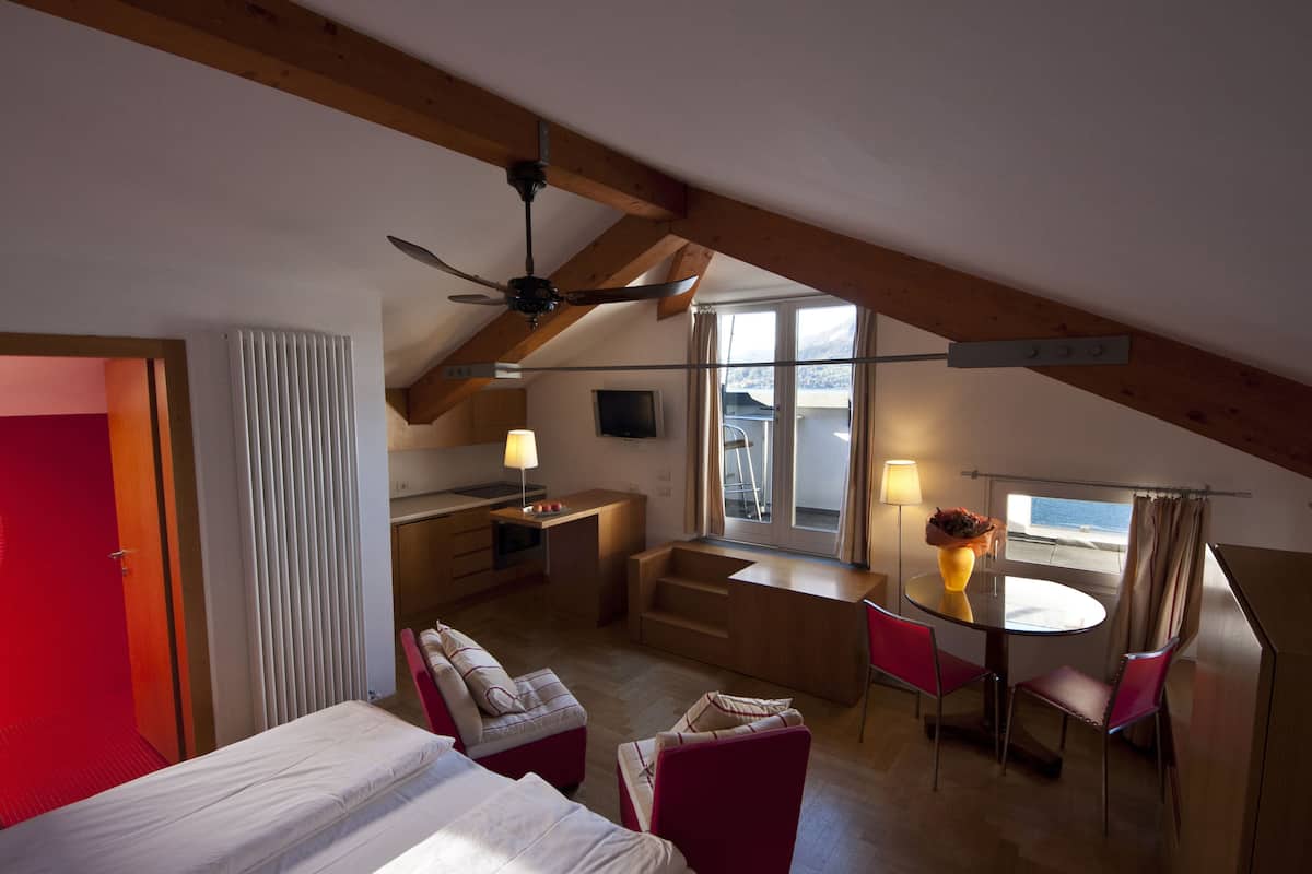 Une pièce de taille modeste comprenant un lit, un bureau, une chaise et une table à manger.