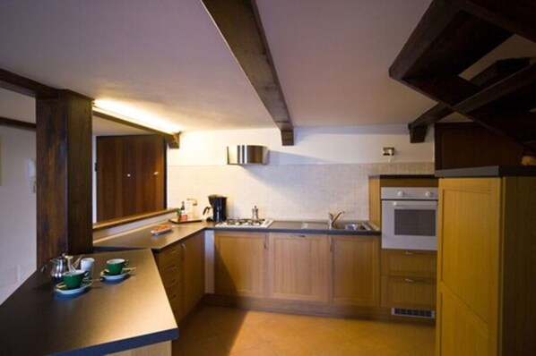 A compact kitchen with wooden cabinets, a built-in oven, and a sink.